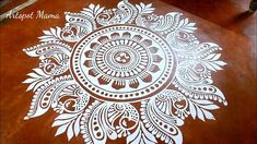 an intricately designed wooden table top with white paint on the surface and brown wood flooring