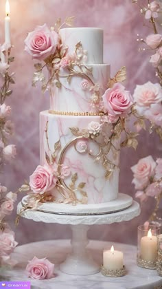 a three tiered cake with pink flowers on it and candles around the cake stand