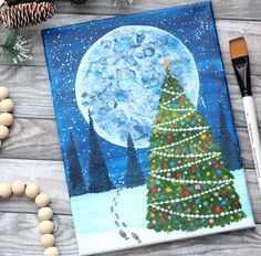 a christmas tree is painted on a canvas next to some beads and other holiday decorations