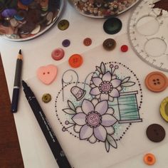 a table topped with buttons and other crafting supplies on top of a white paper