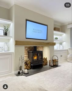 a fireplace with a flat screen tv mounted above it's mantle and logs on the floor