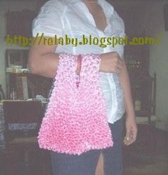 a woman holding a pink crocheted purse