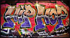 graffiti on the side of a wall with words written in purple, yellow and red