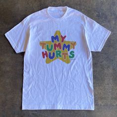 My tummy hurts tee is the perfect funny shirt to wear as your next meme shirt. Inspired by clowncore clothing and kidcore clothes - the playful colors and original hand written lettering will surely bring colors to your days. This funny meme shirt is a perfect addition to your kidcore tee collection or as your daily clown shirt. This clowncore shirt is also the perfect funny gift for her, gift for him or anyone you know who suffers from IBS, survived a diarrhea or for anyone you love who always Silly T Shirt Design, Silly Clothes Aesthetic, Silly Shirt Ideas, My Tummy Hurts Shirt, Character Shirt Design, Weird Shirts Aesthetic, Cursed Tshirt Designs, Shirts That Go Hard, Cool Shirts Aesthetic