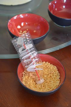 two bowls filled with rice and a plastic drinking straw