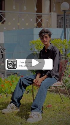 a man sitting on top of a wooden chair in the grass next to a building