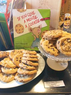 there are many cookies on the table and books in front of them, including one with a mouse