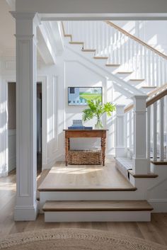 a wooden table sitting on top of a hard wood floor next to a stair case