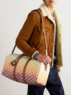 CELINE HOMME's leather-trimmed 'Medium Voyage' holdall is designed for travel, whether you're off on a long holiday or popping out for the weekend. Printed with a signature 'Triomphe' logo, it's crafted from colourful coated-canvas and comes with a silver-tone padlock to keep everything secure. Carry yours by the top handles or the adjustable shoulder strap. Luxury Beige Leather Travel Bag, Designer Leather Weekender Bag, Designer Luggage With Leather Handles For Travel, Luxury Leather Trim Weekender Bag For Business Trips, Luxury Beige Duffle Bag, Luxury Weekender Bag With Leather Backing, Designer Coated Canvas Duffle Bag With Leather Handles, Designer Leather Travel Bag, Designer Duffle Bag With Leather Handles And Coated Canvas