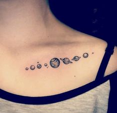 a woman's chest with planets and stars tattoo on her left side ribcage