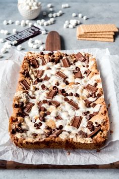 a chocolate chip cookie cake with marshmallows on top and graham crackers around it