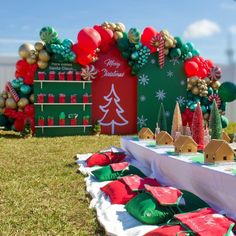 a table with christmas decorations on it in front of a sign and some trees outside