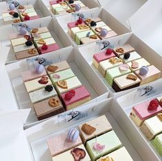 there are many different types of desserts in the box on this table, each one is individually decorated and ready to be eaten