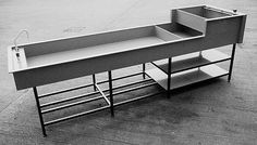 a black and white photo of a desk with an open drawer on the bottom shelf