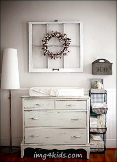 an old dresser is transformed into a baby's crib with a wreath on top