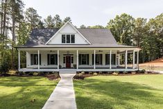 a white house sitting on top of a lush green field