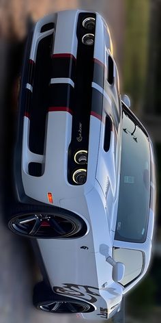 the rear end of a white car with black and red stripes