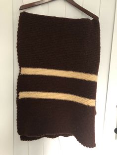 a brown and white striped pillow hanging on a hook