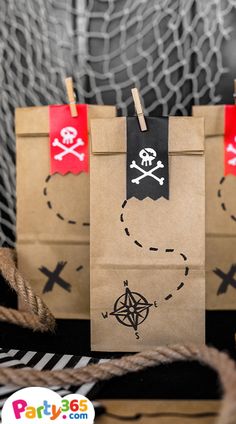 two brown paper bags with pirate symbols on them and some rope hanging from the handles