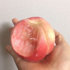 a hand holding an apple with some skin on it