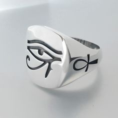 💍 Egyptian's God Ra eye solid silver ring, A five stars-reviewed ring! 📜925 solid silver ring, a minimal handmade item with an eye symbol on the top and the Egyptian characteristic Ankh cross on the bands. 📐 Dimensions 19.0X14.0mm. ⚖. The ring's weight is 13.0gr. ✍ Designed and created by Babuco Jewellery Athens! ♻ A recycled silver Chevalier ring. Available in black patent finishing or black enamel finishing. 🎁 Gift box included. 😊. Thank you for stopping by. ✈ Do You need faster shipping? Symbolic Signet Ring With Polished Finish, Symbolic Engraved Ring With Polished Finish, Ankh Ring, Egyptian Man, Egyptian Cross, Egyptian Eye, Ankh Cross, Eye Symbol, Gods Eye