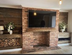 an old brick fireplace with a flat screen tv mounted on it's mantle and man standing in the doorway