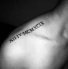 a man's arm with roman numerals tattooed on the upper part of his left arm