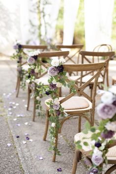 rows of wooden chairs with purple flowers on them and greenery growing up the back