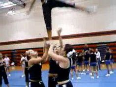 two cheerleaders are doing tricks in the gym