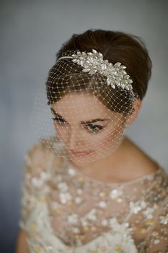 a woman in a wedding dress with a veil over her head and flowers on it