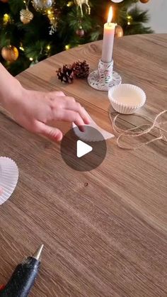 someone is making cupcakes with paper plates on a table in front of a christmas tree