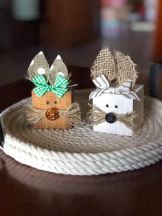 two small wooden deers are on a rope with bows in their ears, and one is wearing a green bow