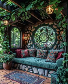 a green couch sitting under a circular window in a room filled with plants and rocks