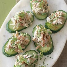 cucumbers stuffed with crab salad on a white platter