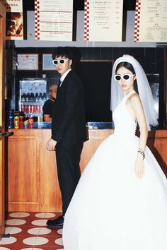 a bride and groom are standing in front of a restaurant counter wearing sunglasses that read, i do not know