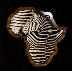 two zebras standing next to each other on top of a wooden plaque in the shape of a heart