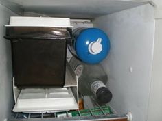 an open refrigerator with various items in it and a blue ball on the top shelf