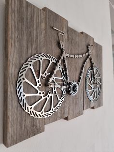 there is a wooden wall hanging with two bikes on it