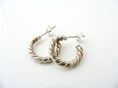 Offered for sale is a pair of Tiffany and Co. Sterling Silver 18K Gold Rope Hoop Earrings. The style is classic Tiffany, making it a piece that you will most certainly use over and over again. Great piece to wear to work, or for just going to dinner with friends in jeans or a pretty dress. Super versatile and chic piece! It's like a piece of art - right on your ears! Because the earrings are two tone, it will go well with all of your other pieces - whether it be sterling silver, white gold or ye Small Hoop Earrings With Sterling Silver Clasp For Anniversary, Small Hallmarked White Gold Hoop Earrings, Small Hoop White Gold Hallmarked Earrings, Small Hoop Hallmarked Earrings For Wedding, Handmade Small Hoop White Gold Earrings, Handmade White Gold Small Hoop Earrings, Handmade Small Hoop Earrings In White Gold, White Gold Small Hoop Earrings Hallmarked, Classic Handmade Hoop Earrings For Anniversary