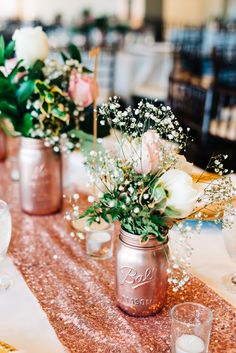 there are flowers in mason jars on the table