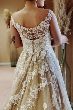 a woman wearing a wedding dress with flowers on it