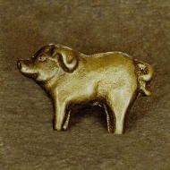 a gold colored dog brooch sitting on top of a table next to a wall