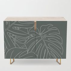 the sideboard is painted with an image of tropical leaves on green and gold legs