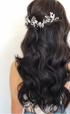 the back of a woman's head wearing a hair comb with flowers on it