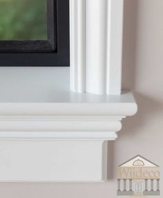 a white shelf with a black frame on it and a bird perched on the ledge