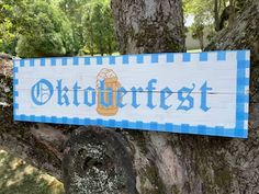 a blue and white sign that says oktoffefest hanging from the side of a tree