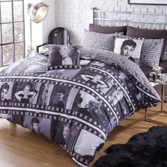 a bed with black and white pictures on the comforter, pillows and pillow cases