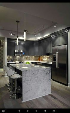 a modern kitchen with marble counter tops and stainless steel appliances