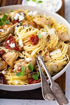 pasta with chicken, tomatoes and fettuccine in a white bowl