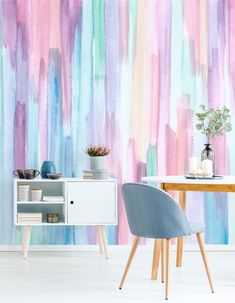 a room with a table, chair and wallpaper that has colorful stripes on it